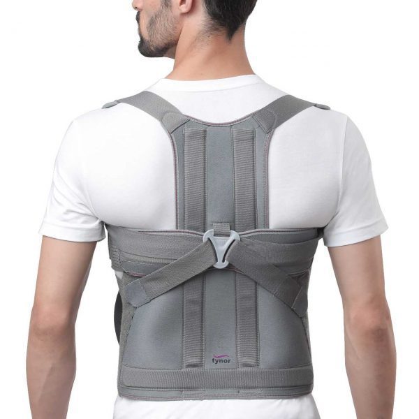 ew of person wearing gray Tynor orthopedic posture correction brace over white T‑shirt with adjustable straps Nairobi Kenya